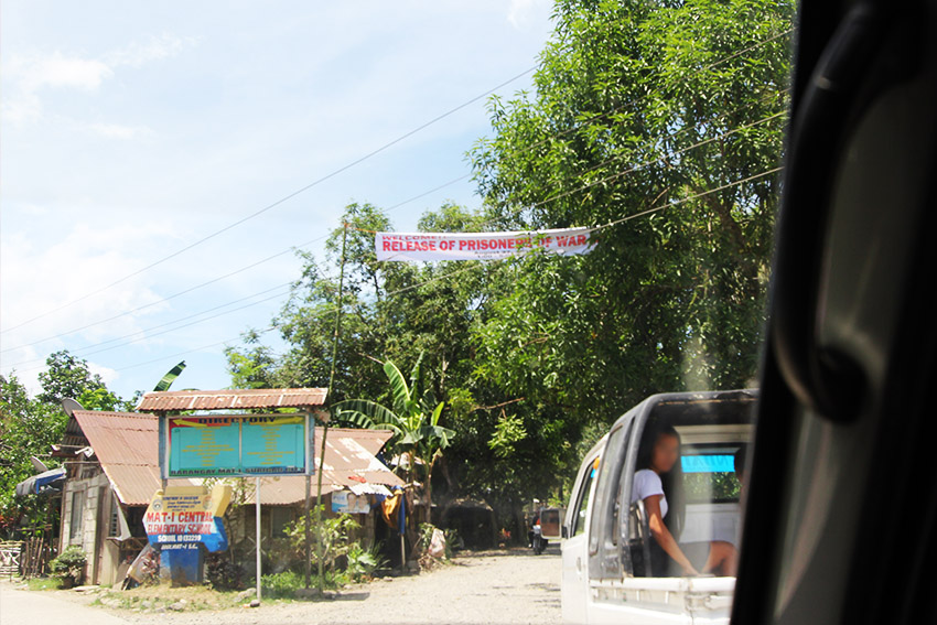 SIGNAGES. Tarpaulins hang kilometers away from the village in Barangay Mat-i where the release of prisoners of war was held. 
