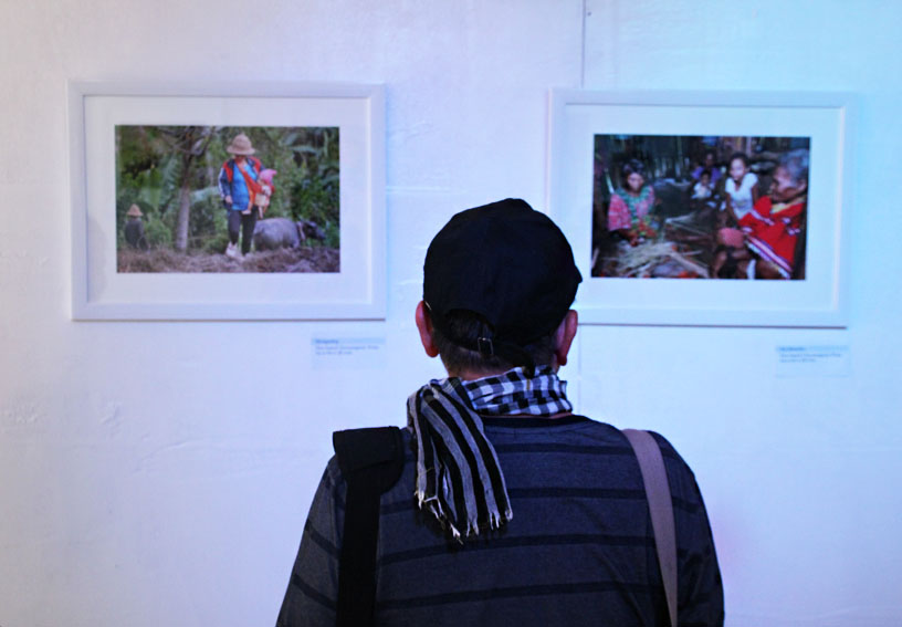 Veteran photojournalist Rene Lumawag looks at the photographs on display for the "Kinabuhi: A Photo Exhibit" inside the Durian Dome, in People's Park, along Palma Gil street, Davao City. The photo exhibit, which features the 11 tribes of Davao City, opened on Monday afternoon, August 15. (Paulo C. Rizal/davaotoday.com)