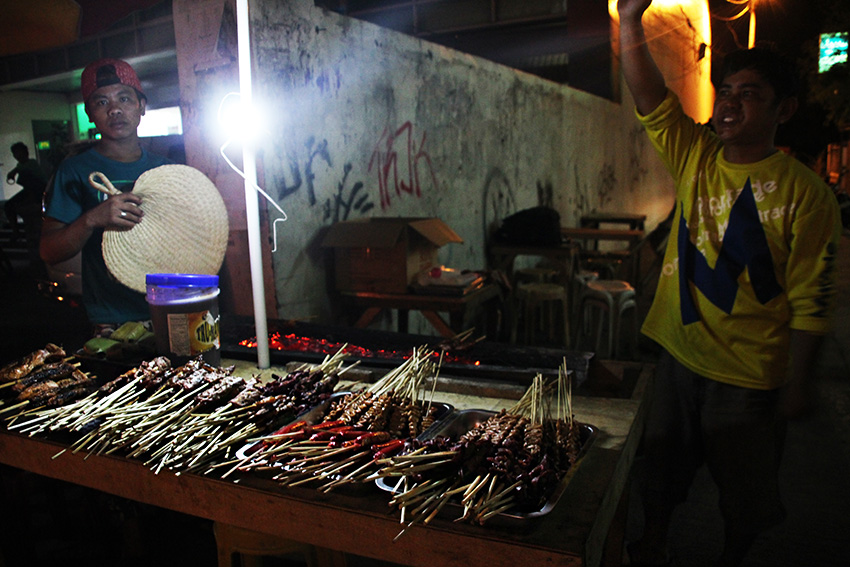 Barbecue seller Laonel Abunas, along with a handful of other street venders, transferred to a space located along C.M. Recto continue selling on Wednesday night, August 3 after Mayor Sara Duterte ordered the closure of the night market.(Paulo C. Rizal/davaotoday.com)