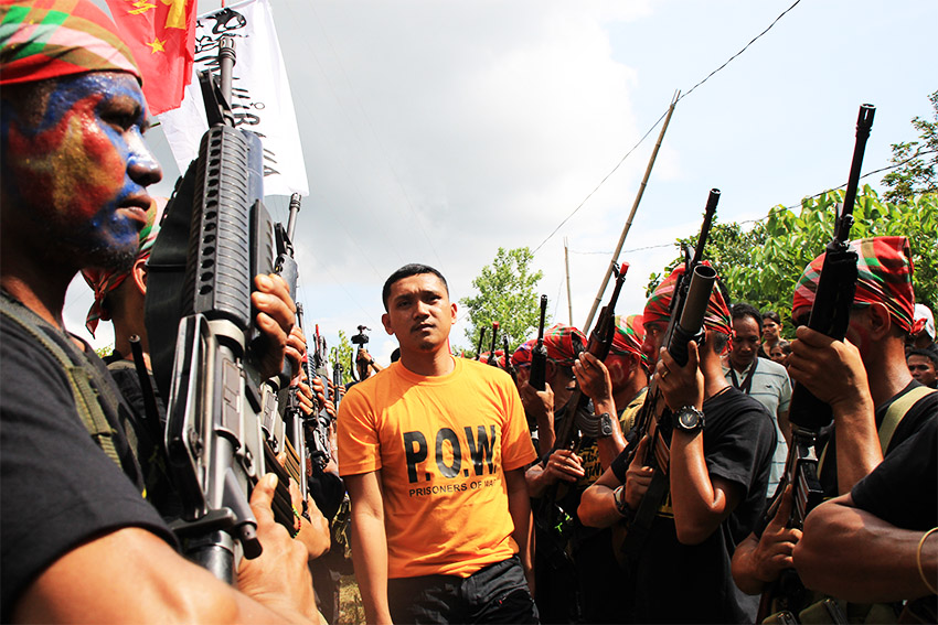 Police Officer 1 Michael Grande of Banaybanay Municipal Police station, who was one of the two prisoners-of-war released by the New People's Army in Davao Oriental on Friday, August 26, marched in between NPA guerrilla fighters during the ceremony. (Earl O. Condeza/davaotoday.com)