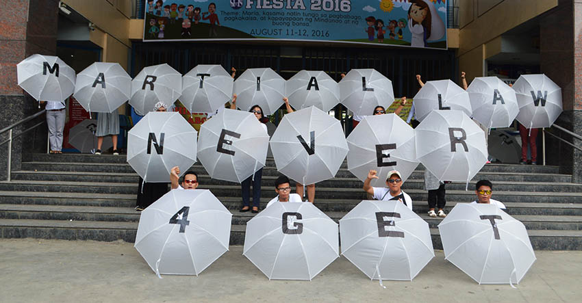NEVER FORGET. Using umbrellas, members of Konsyensya Dabaw movement call on the public not to forget the Martial Law as they renew their call to President Rodrigo Duterte to have the burial of the late strongman, President Ferdinand Marcos, Sr., in Batac, Ilocos Norte. The group held their protest action in front of the Ateneo de Davao University on Sunday, August 21, 2016. (Medel V. Hernani/davaotoday.com)
