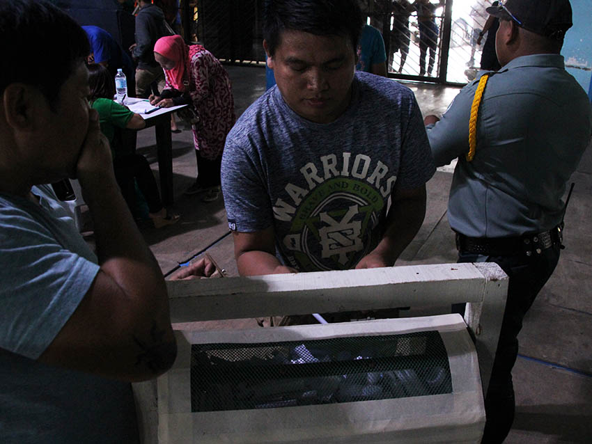 RAFFLE. An ukay-ukay stall owner drops his name in a raffle drum inside the Davao City Recreation Center on Monday, August 8. Out of the estimate 600 stall owners of ukay-ukay, 0nly 137 names of venders were selected by drawing lots. Those who were chosen will be allowed to sell at the night market in Roxas Avenue. (Paulo C. Rizal/davaotoday.com)