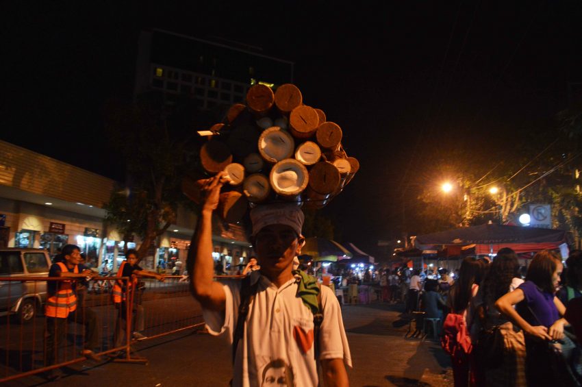 A man tries his luck selling bamboo coin banks in Roxas night market. (Medel V. Hernani/davaotoday.com)