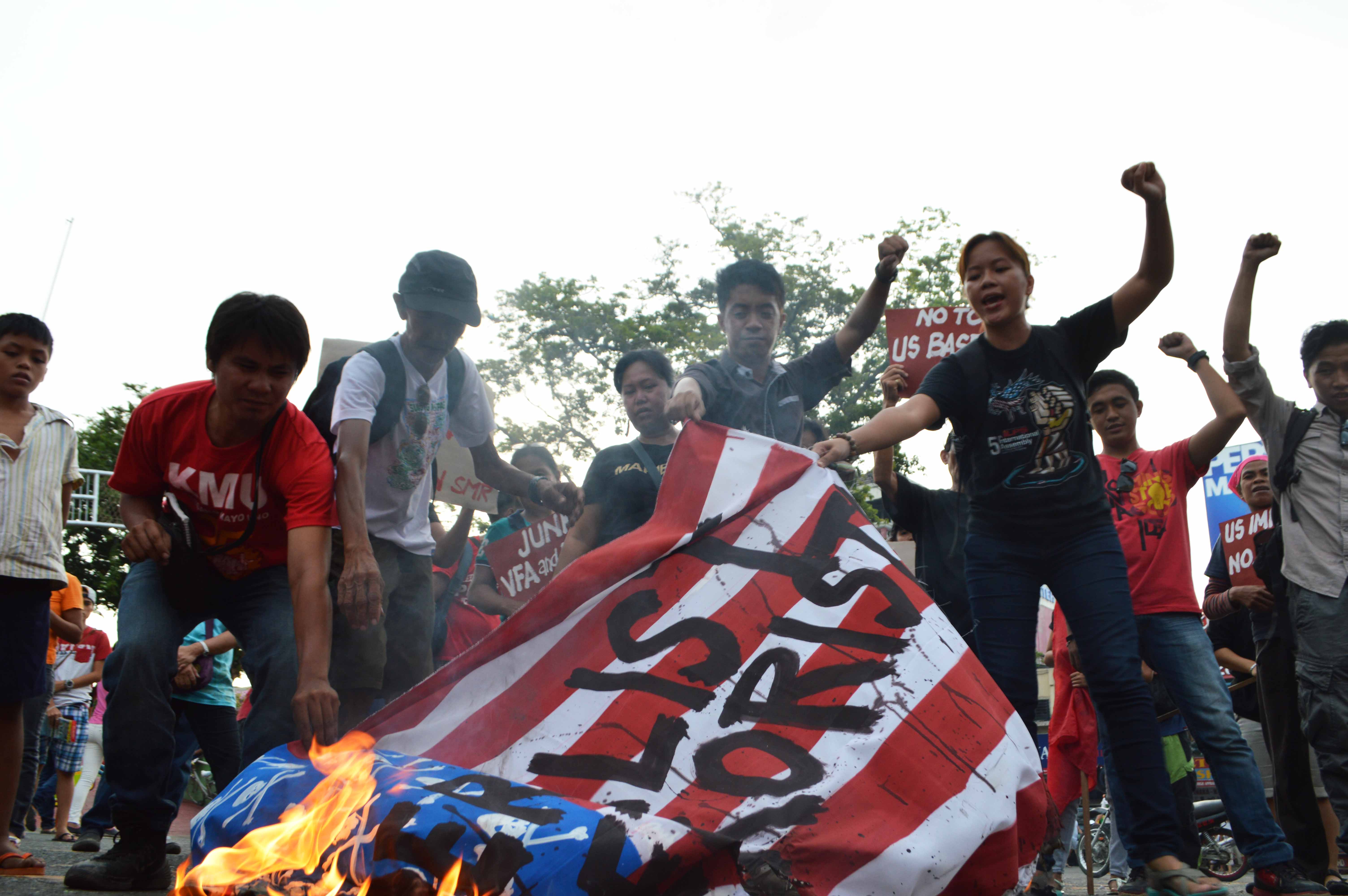 Protesters shout "US imperialist No. 1 terrorist" as they burn a US flag in a rally in Davao City on Sunday, September 11, 2016.