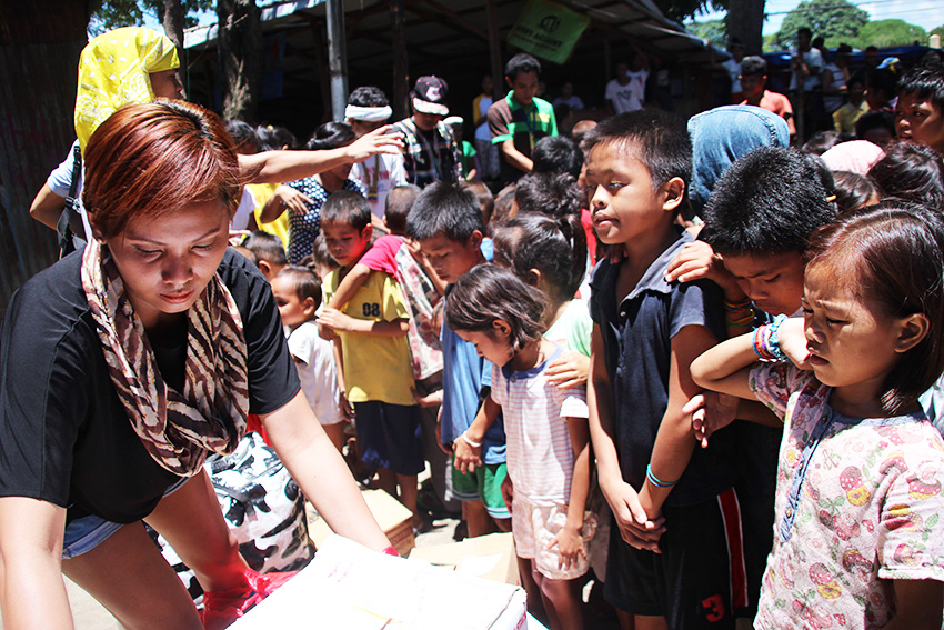 DONATIONS. Manobo children receive school supplies from the Youth for Development, represented by Willariza Veloso Tigle on September 22, Thursday morning. (Paulo C. Rizal/davaotoday.com)