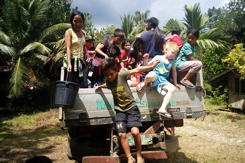 EXCITED. Students of the Alternative Learning Center for Agricultural Development and Tribal Filipino Program of Surigao del Sur Inc. hop onto the truck on their way to Sitio Han-ayan on September 3, Saturday. (Earl O. Condeza/davaotoday.com)
