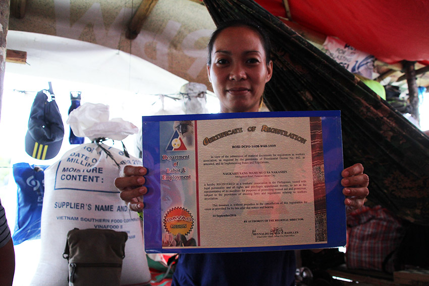 Estella Mae L. Partoza, one of the 75 striking workers of the frozen food exporter Nakashin Davao International, shows a certificate declaring the workers' union, Nagkahiusang Mamumuo sa Nakashin (Namana) is registered with the Department of Labor and Employment. (Paulo C. Rizal/davaotoday.com)