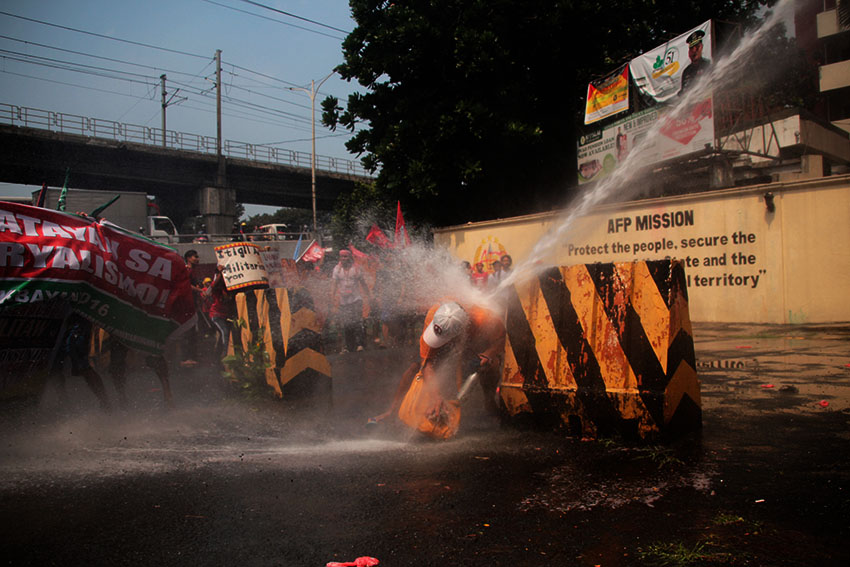 A protester receives the full might of a water cannon fired at him from the Army's national headquarters, Camp Aguinaldo in Quezon City during a protest rally led by national minority alliance group SANDUGO on Tuesday, October 18. (Paulo C. Rizal/davaotoday.com)