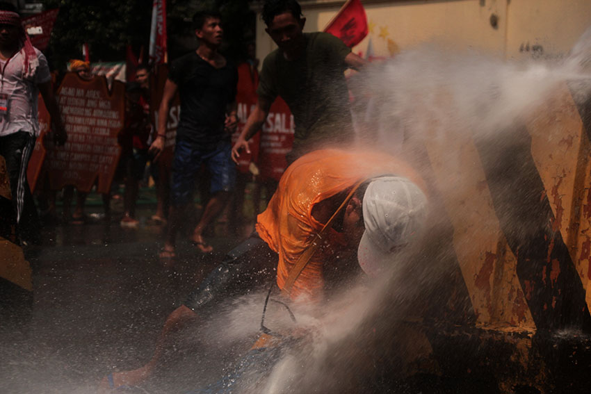 A protester receives the full might of a water cannon fired at him from the Army's national headquarters, Camp Aguinaldo in Quezon City during a protest rally led by national minority alliance group SANDUGO on Tuesday, October 18. (Paulo C. Rizal/davaotoday.com)