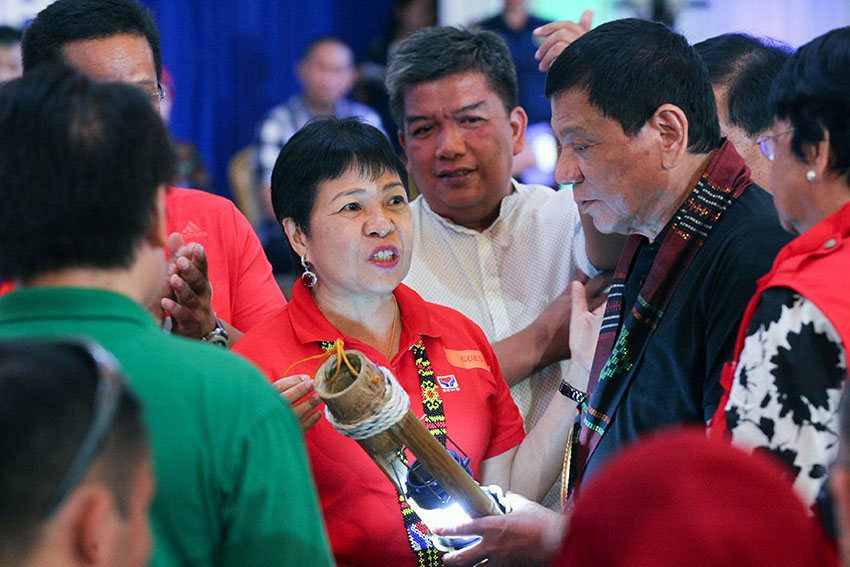 President Rodrigo Duterte examines the symbolic lamp that represents the commitment of various agencies to address the issue of malnutrition and hunger among the marginalized sectors in Autonomous Region in Muslim Mindanao during the launch of the Comprehensive Reform and Development Agenda for ARMM and other Conflict-Affected Areas in Regions 9, 10, and 12 at Shariff Kabunsuan Cultural Complex in Cotabato City on Saturday, Oct. 29. Also in the photo are Department of Social Welfare and Development Undersecretary Mae Fe Templa and ARMM Governor Mujiv Hataman.  (SIMEON CELI JR./PPD)