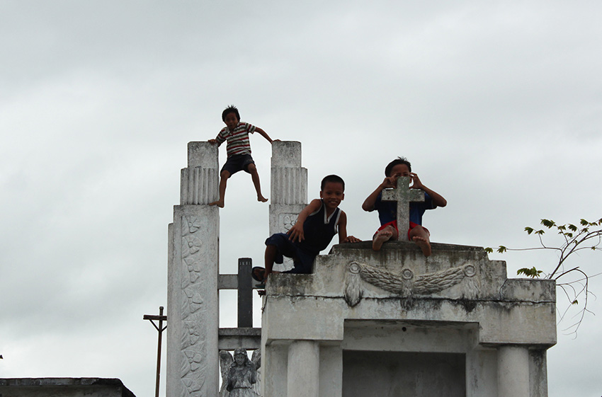 PLAYGROUND FOR CHILDREN. Children living near the Wireless Catholic Cemetiry in Davao City, enjoy their semestral break playing on top of tombs. (Medel V. Hernani/davaotoday.com)