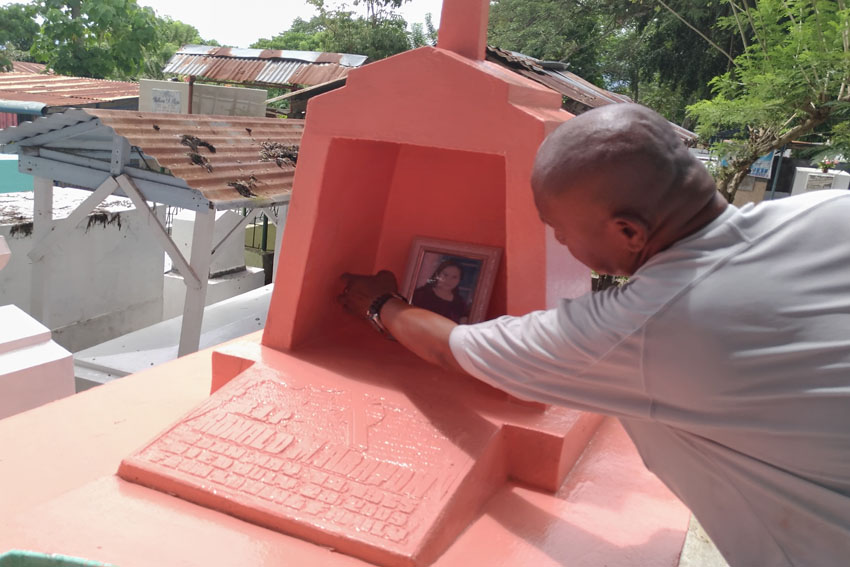 Rodrigo Valles preps up his daughter's tomb painting it peach inside the Mintal Public Cemetery before All Saints' Day. Valles said he makes it appoint to change the color of his daughter's tomb every year. (Zea Io Ming C. Capistrano/davaotoday.com)