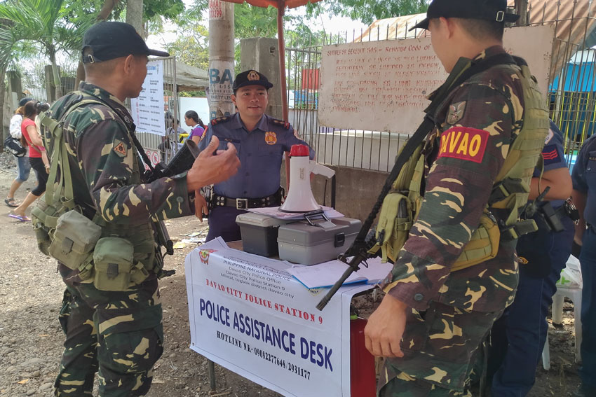 Members of Task Force Davao and the Philippine National Police beef up the security outside Mintal Public Cemetery in Tugbok District, Davao City on Monday, Oct. 31. The police also put up an assistance desk along the road. (Zea Io Ming C. Capistrano/davaotoday.com)