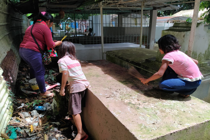 Cousins Dat-dat, 9 and Hazel, 11 clean a tomb inside the Mintal Public Cemetery in Davao City a day before the traditional observance of All Saints’ Day on Nov. 1. The girls are paid P10 for sweeping. (Zea Io Ming C. Capistrano/davaotoday.com)