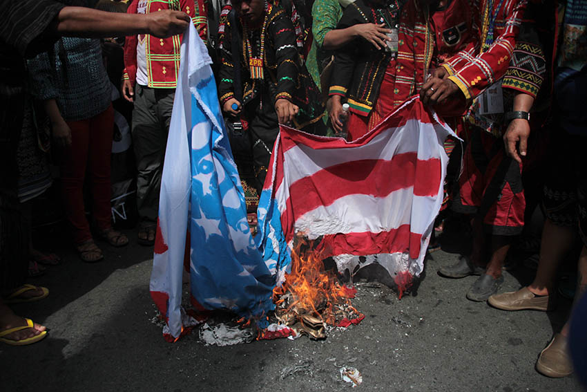 ANTI-US PROTEST. Leaders of indigenous peoples and Moro alliance, SANDUGO burn a mock flag of the United States in a protest rally held in Mendiola, Manila to condemn the violent protest dispersal at the US Embassy on Oct. 19. (Paulo C. Rizal/davaotoday.com)