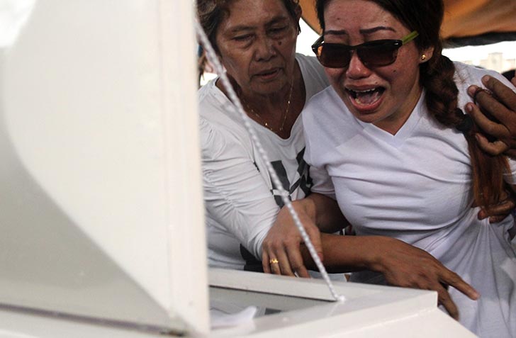 MOTHER'S GRIEF. Overseas Filipino worker Erlinda Cagalitan wails at the coffin of her 2-year old son, John Earl at the Davao Memorial Park on Wednesday Nov. 23. The boy died after being beaten by his guardian, Ronilo Alcain. (Paulo C. Rizal/davaotoday.com)