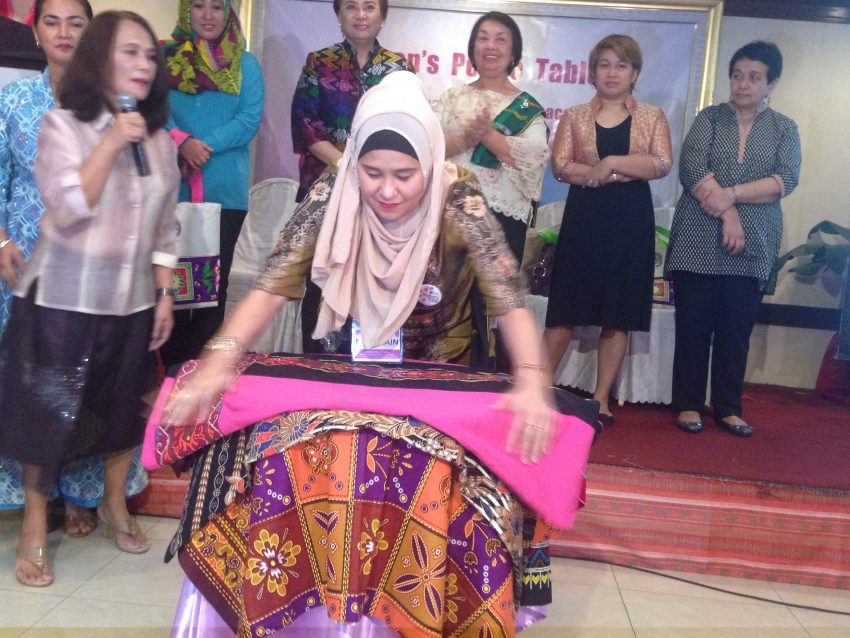 A woman participant to the opening of the Women's Peace Table lays a the traditional cloth to signify the unity of women in Mindanao to actively participate in the peace process. The opening was held at the Royal Mandaya Hotel in Davao City on Monday, Nov. 28. (Zea Io Ming C. Capistrano/davaotoday.com)