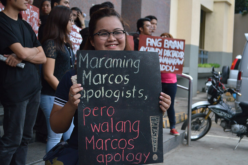 A student of the Ateneo de Davao University carries a placard during the anti-Marcos burial rally in front of the university in Davao City on Wednesday, Nov. 23. The placard says there are a lot of apologists for the late dictator Ferdinand Marcos, but there was never an apology from the Marcos family. (Medel V. Hernani/davaotoday.com)