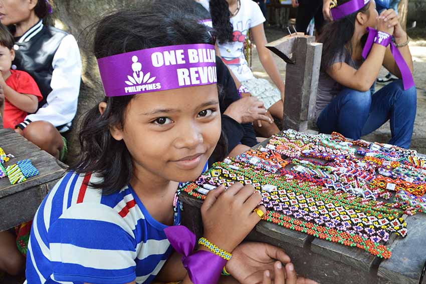 A Lumad girl smiles while selling bracelets made of beads with different designs during the launching of the One Billion Rising Revolution at the United  Church of Christ in the Philippines Haran compound  in Fr. Selga St., Davao City. (Medel V. Hernani/davaotoday.com)