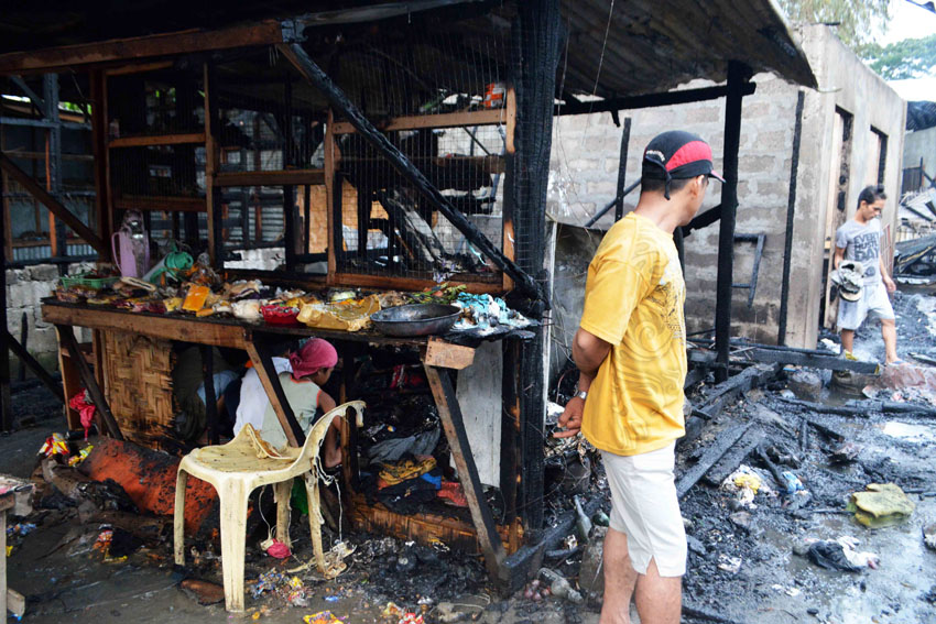 SOURCE OF LIVING. A resident in Purok A, Barangay 19-B, in Davao City checks on what was left after their store was razed by a fire on Tuesday afternoon, Dec. 27, 2016, along with 22 other houses. (Medel V. Hernani/davaotoday.com)