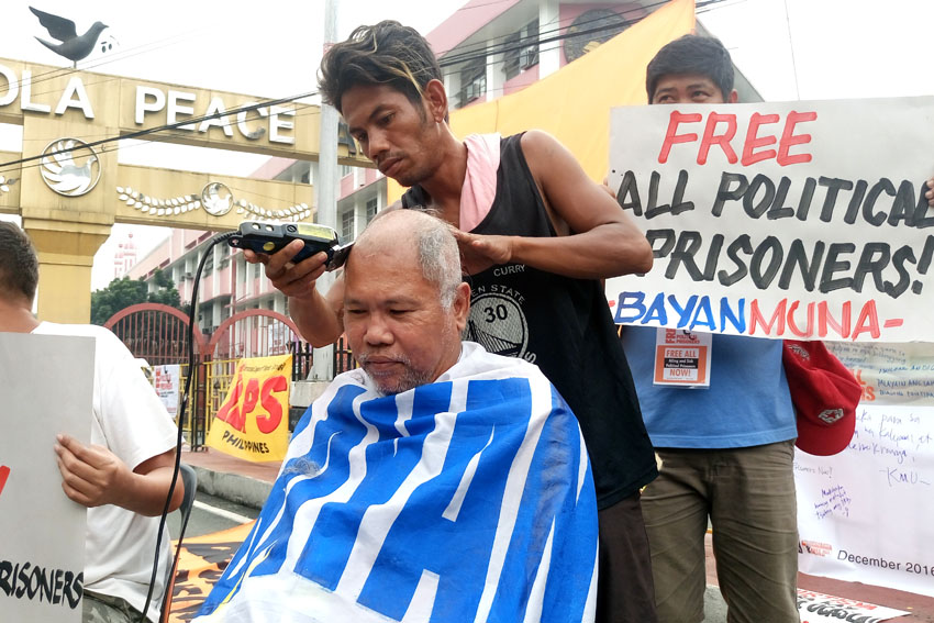 A member of Bayan Muna Partylist shaves his hair to support the call for the immediate release of political prisoners during a protest action in Mendiola Bridge in Manila on Thursday, Dec. 8. (Contributed photo) 