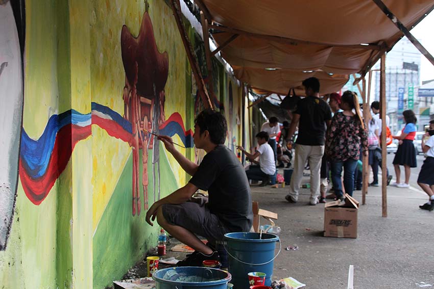 FAMILY. An artist paints a child going to church as part of the mural painting organized by the Inter-Agency Council Against Human Trafficking. (Paulo C. Rizal/davaotoday.com)