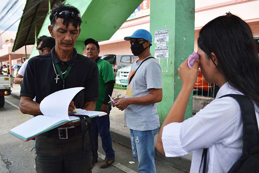 A traffic enforcer gives a citation ticket to a student in Davao City after she crosses the street. At least four pedestrians have been apprehended on Friday afternoon, Dec. 2, along JP Laurel Street in Davao City after they violated the Anti-Jaywalking ordinance. Violators are obliged to undergo seminar and pay fine of P100 or render community service thru City Social Services and Development Office. (Medel V. Hernani/davaotoday.com)