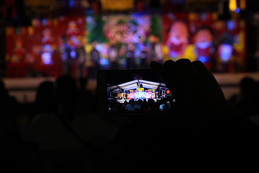 A man from the audience records the performance of one of the entries to the Koro sa Pasko, a carol singing contest organized by the City Tourism Operations Office of Davao City on Tuesday night, Dec. 20. (Paulo C. Rizal/davaotoday.com)