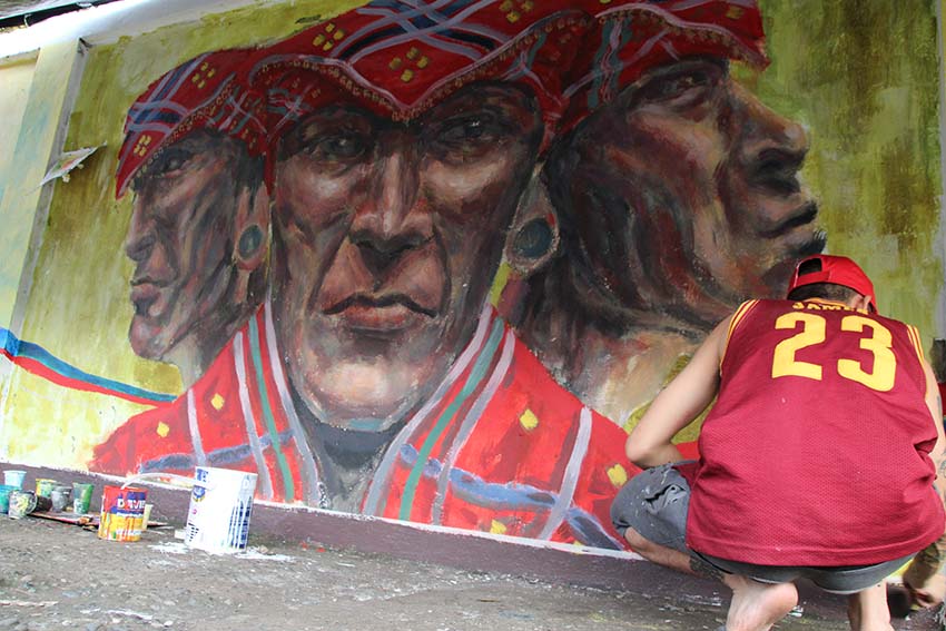 Fine Arts student Clye Laudato says he chose to draw the Lumad in his mural to create a sense of Davao. Laudato's work along with some 60 others will be unveiled on Dec. 12 as part of the mural painting activity of the Inter Agency Council Against Trafficking in Davao Region. (Paulo C. Rizal/davaotoday.com)