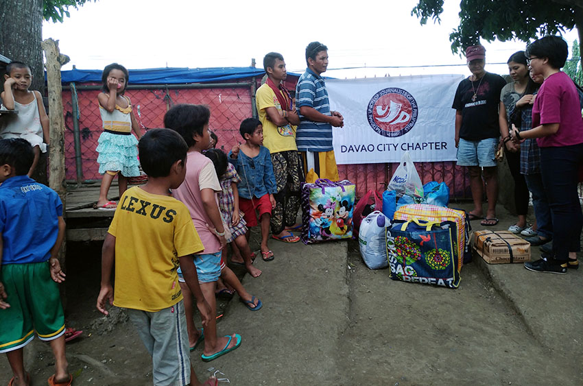 Datu Mintroso Malibato (in blue striped shirt), spokesperson of indigenous peoples group, Karadyawaan thanks the members of the National Union of Journalists of the Philippines in Davao City for giving toiletries and clothes for more than 200 indigenous people evacuees sheltered inside the Haran compound of the United Church of Christ in the Philippines on Thursday morning, Dec. 22. (Photo by NUJP-Davao)