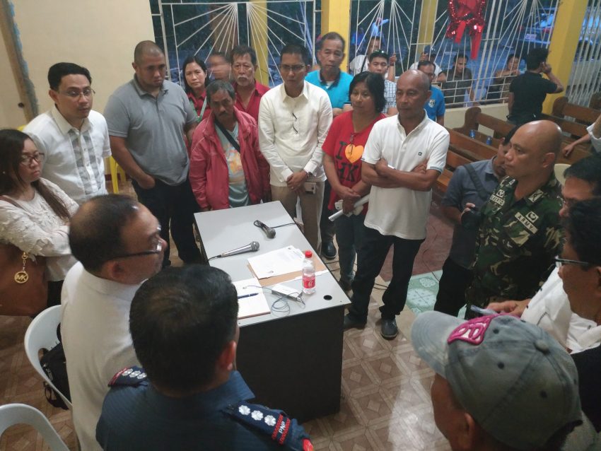 Department of Agrarian Reform Undersecretary for Legal Affairs Atty. Luis Pangulayan (standing on the left side of the policeman), summarizes the points discussed during the dialogue between the agrarian reform beneficiaries and the Lapanday Foods Corporation on Monday evening, Dec. 19. DAR stressed during the dialogue that the cease and desist order issued in favor of the farmers should be respected by all parties. (Zea Io Ming C. Capistrano/davaotoday.com)