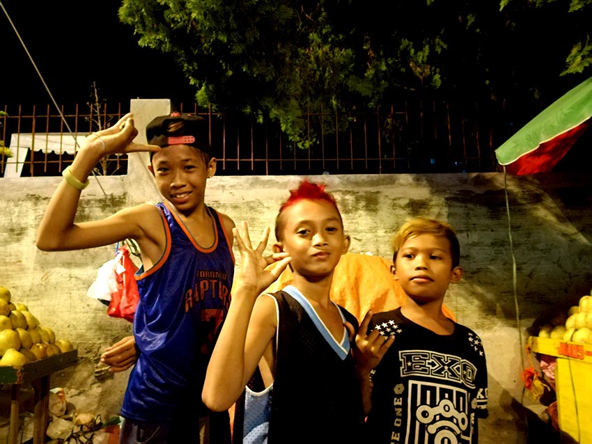 ROXAS CAROLLERS. From left to right: Yuko, 14; Inggo, 12; and CG, 12 pose for the camera while taking a break from caroling in Roxas Avenue, Davao City on Wednesday, Dec. 21. (Paulo C. Rizal/davaotoday.com)