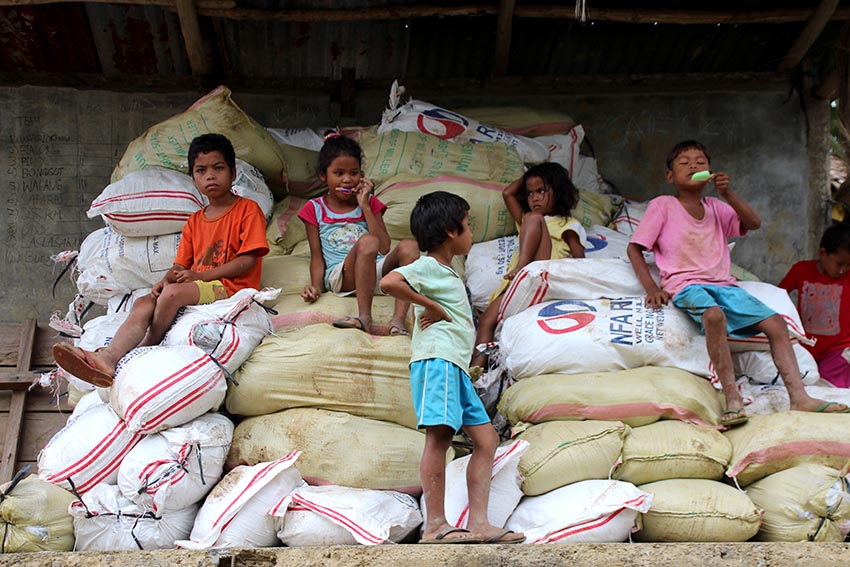 RESTING. A group of Manobo children sit on sacks of relief goods in Sitio Tibucag, Barangay Dagohoy in Talaingod, Davao del Norte on Wednesday, Nov. 30. (Paulo C. Rizal/davaotoday.com)