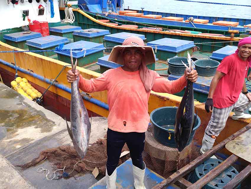 A laborer carries tuna that weigh at least 15 kilos each as they unload tons of tunas from a Filipino fishing vessel from inside the General Santos Fish Port Complex in General Santos City on Thursday morning, Dec. 29, 2016. (Zea Io Ming C. Capistrano/davaotoday.com)