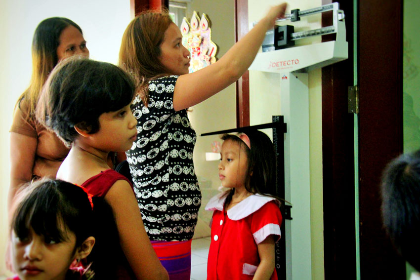 GROWTH MONITORING. A personnel at the Archbishop Nutrition Center records the weight and height of the children as part of nutritional status monitoring.  The center, located Pag-Asa Street, Fatima, Davao City provides free lunch to malnourished children.(Maricar Emata/davaotoday.com)