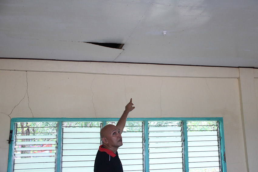 NEWLY DILAPIDATED. Dr. Harris Sinolinding, a professor of the Cotabato Foundation College of Science and Technology points to a dangling ceiling panel in a classroom building that was only three years old. Sinolinding is among the faculty who joined a protest camp inside the school grounds to demand the ouster of school president Dr. Samson Molao, whom he accuses of bypassing the procurement process by giving projects to business and construction firms owned by relatives. (Paulo C. Rizal/davaotoday.com)