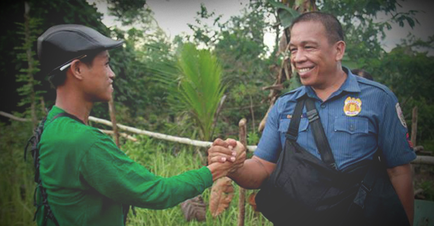 MOMENT OF PEACE. A member of the New People’s Army and a police escort shake hands as they meet during the NPAs release of its captured soldiers in San Luis, Agusan del Sur in May 2016. The photo was taken by Ace Morandante and was awarded during the Globe Media Excellence Awards in 2016. (davaotoday.com file photo)