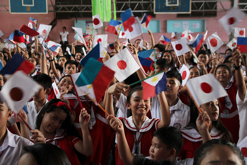 SIDE BY SIDE. Young students of the Mindanao Kokusai Daigaku in Davao City wave Philippine and Japanese flags during the visit of Japanese Prime Minister Shinzo Abe on Friday, Jan. 13. Some 1,700 students from the school welcomed Abe. (Paulo C. Rizal/davaotoday.com)