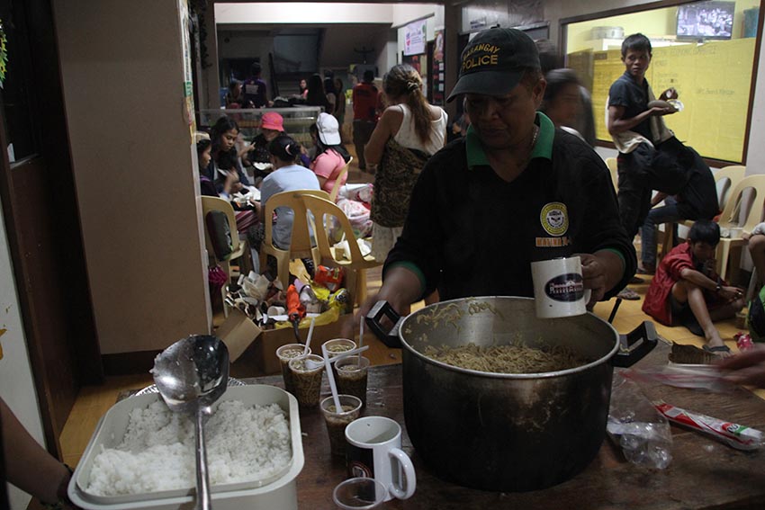 TEMPORARY RELIEF. A local official in Barangay Matina Crossing prepares cupfuls of instant noodles to distribute to residents who evacuated to the barangay hall after the swelling of the Matina Pangi river on Monday night, Jan. 2, 2016. (Paulo C. Rizal/davaotoday.com)