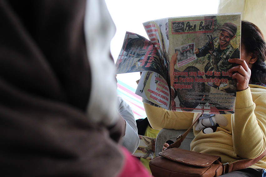 A local resident reads the communist publication Pasa Bilis! (Pass it Quickly) during a peace forum organized by the National Democratic Front in Barangay Makopa, Laak, Compostela Valley on Tuesday, Jan. 10. (Paulo C. Rizal/davaotoday.com) 