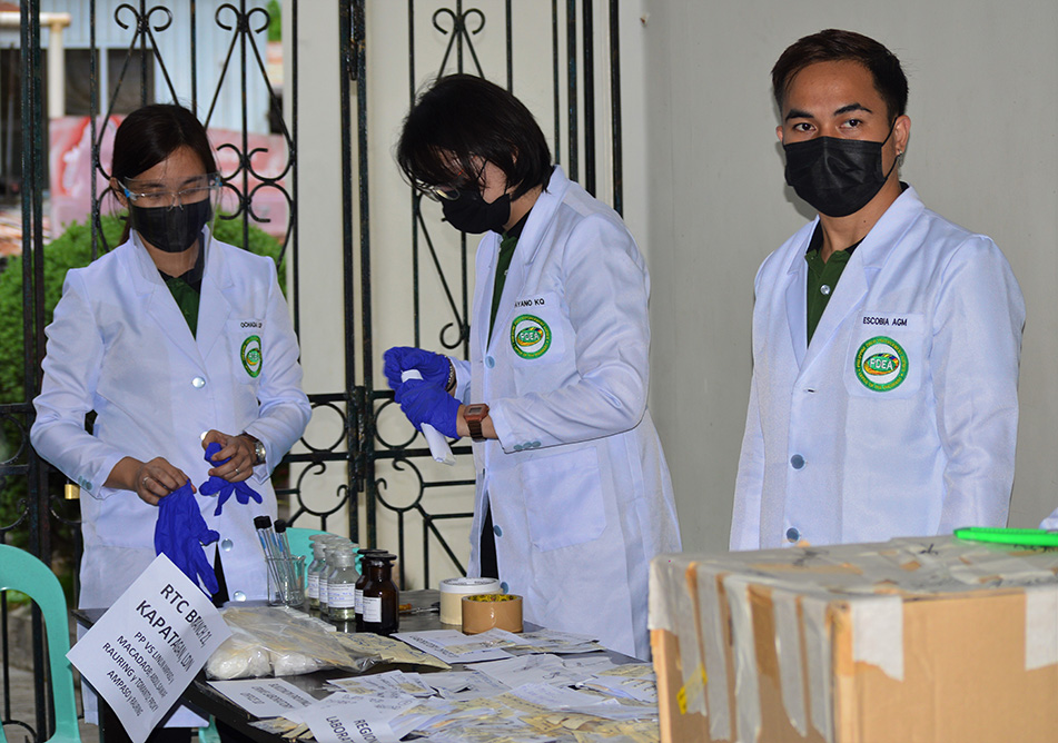 photo of PDEA technicians inspecting metamphetamines before incineration.
