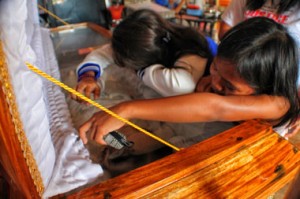 GRIEVING FOR THEIR SLAIN MOTHER. The daughters of slain Barug Katawhan leader Cristina Jose cry in sorrow on their mother’s coffin Tuesday in Poblacion village, Baganga town, Davao Oriental. Jose was shot to death Monday by three motorcycle-riding men while she was on her way to Davao City. Her family said she was killed for defending the Pablo victims’ rights and interests. (davaotoday.com photo by Ace R. Morandante)