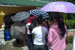 UMBRELLAS. Voters under their shade of umbrellas flock to voting precincts in Poblacion of Paquibato District. (davaotoday.com photo by Earl O. Condeza)