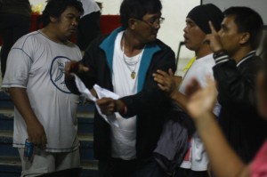 CONFRONTATION. A supporter of re-electionist Olanolan (center) is confronted by watchers of Trajera as the former tries to stop the canvassing and demand a recount. The Olanolan supporter was later escorted out by cops.(davaotoday.com photo by John Rizle L. Saligumba)