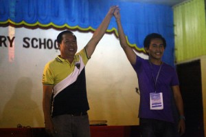PROCLAMATION. Rolando Trajera (left) has his arm raised as he is proclaimed the new barangay chairman of Bucana 76-A in Monday's barangay election. (davaotoday.com photo by John Rizle L. Saligumba)